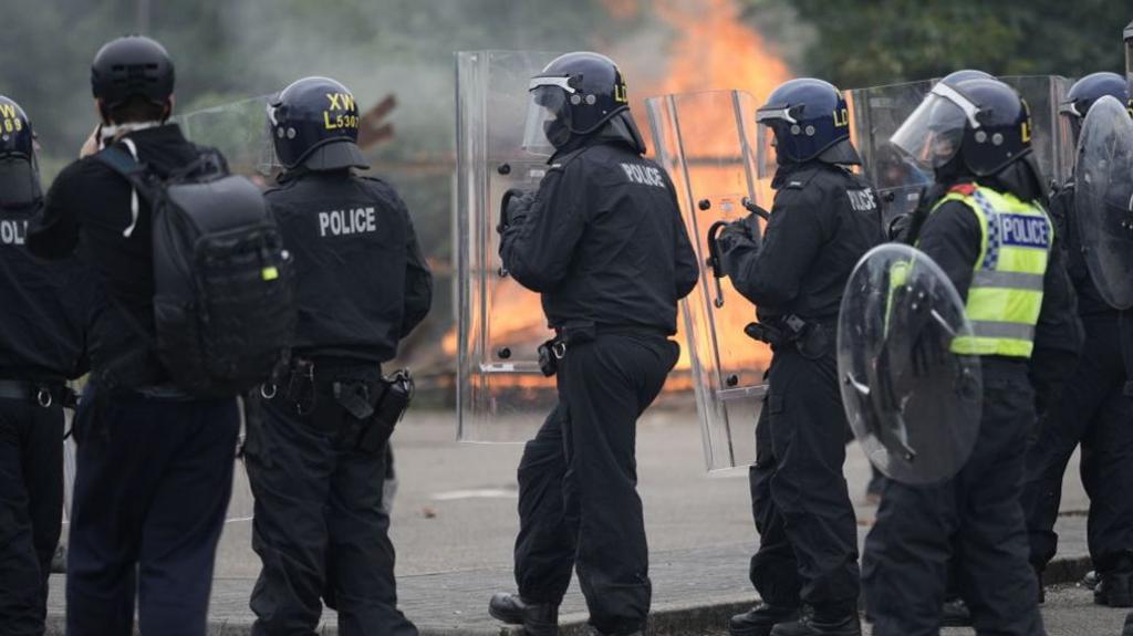 Image of police in riot gear at the scene of disorder on 4 August